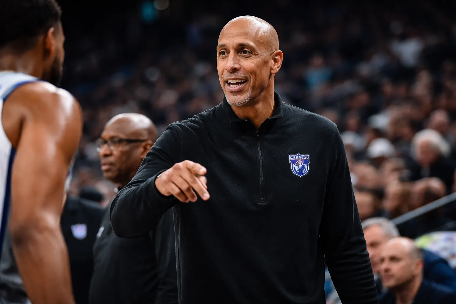Doug Christie stands on the sidelines during a Sacramento Kings game, gesturing to players.