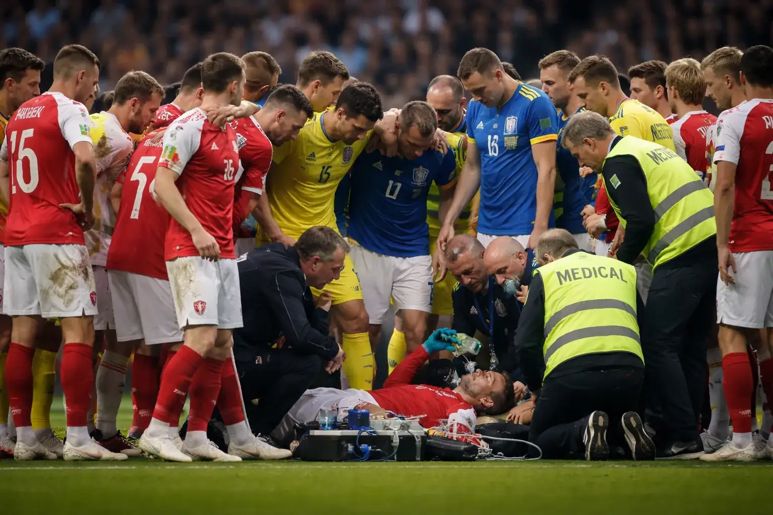 Danish midfielder Christian Eriksen walking from the field after receiving medical attention.