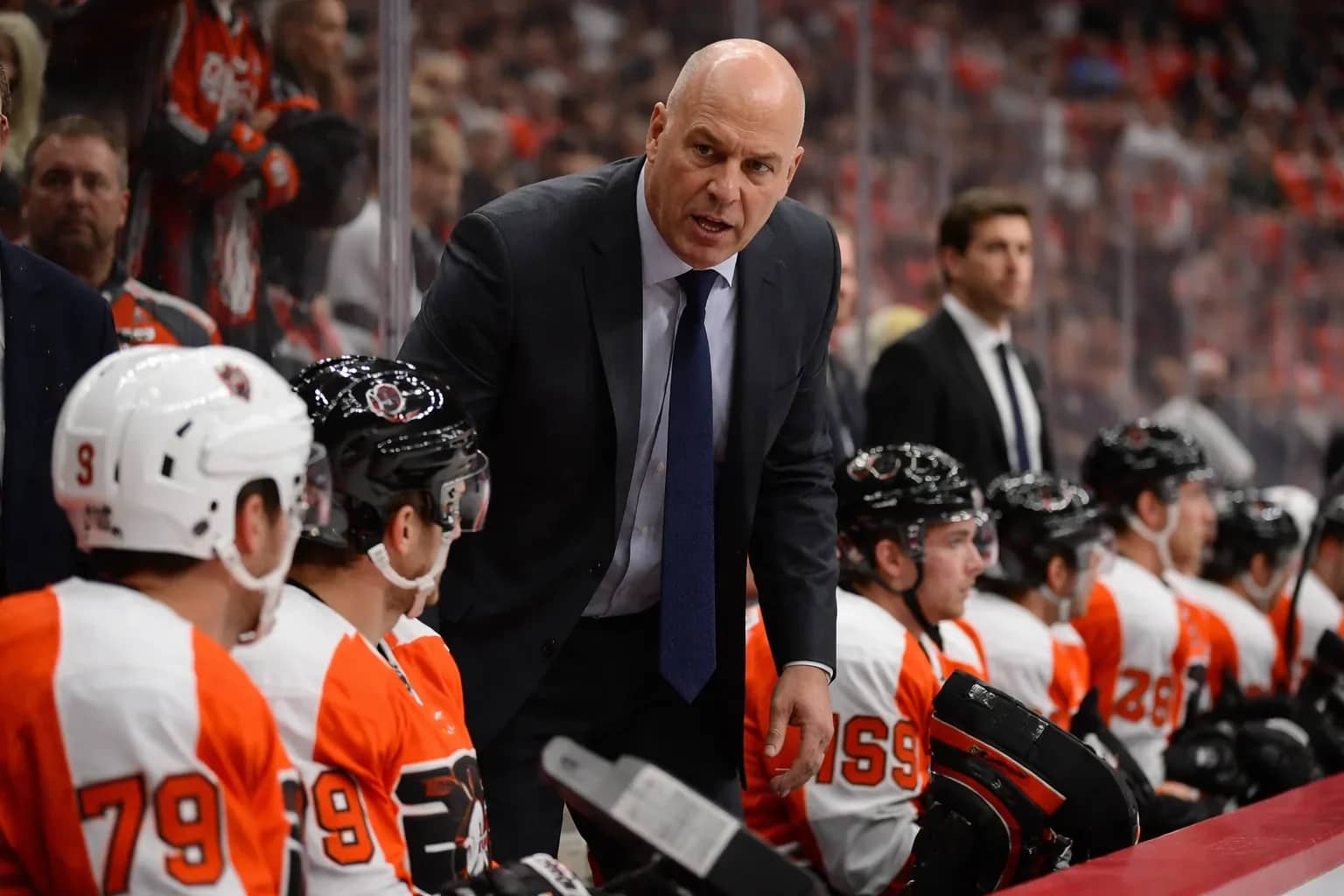 Rick Tocchet looking on from the Philadelphia Flyers bench during a game.