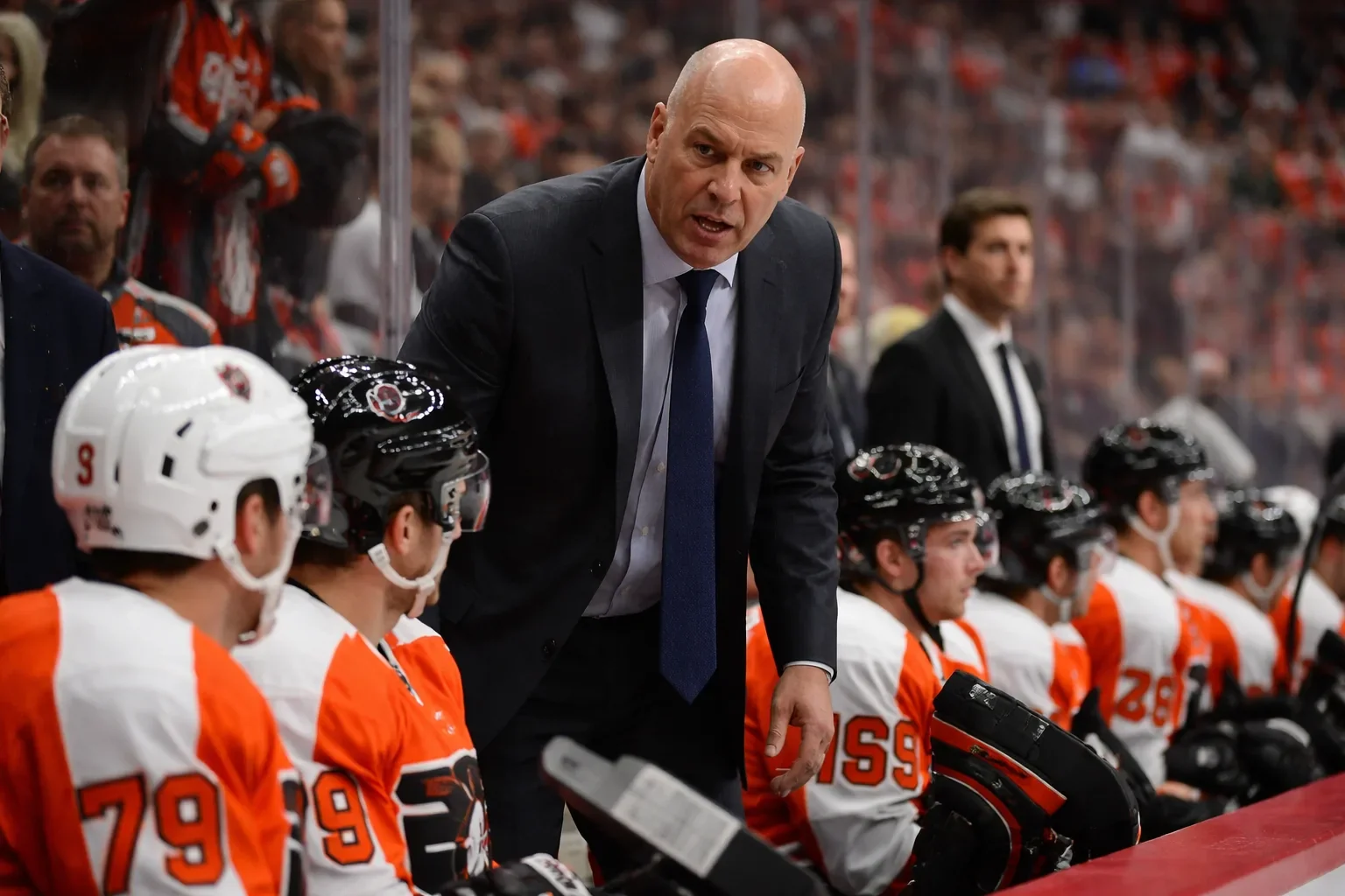 Rick Tocchet looking on from the Philadelphia Flyers bench during a game.